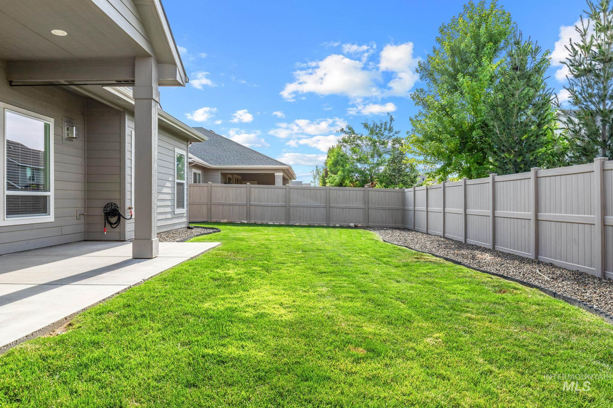 2934 East Murchison Street Meridian, ID 83642 - Photo 42 of 44 Expansive backyard with manicured lawn, a covered patio, and privacy fencing
