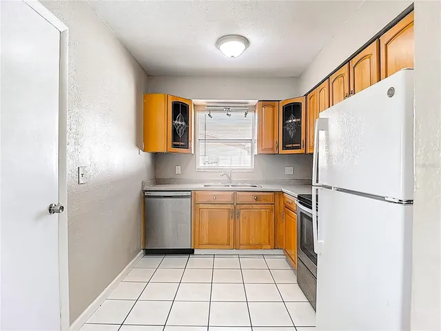 a kitchen with a refrigerator a stove top oven and sink