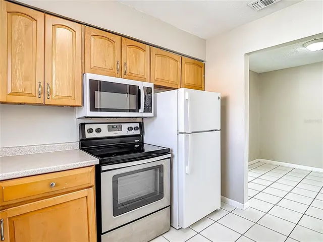 a kitchen with granite countertop cabinets stainless steel appliances and a counter space