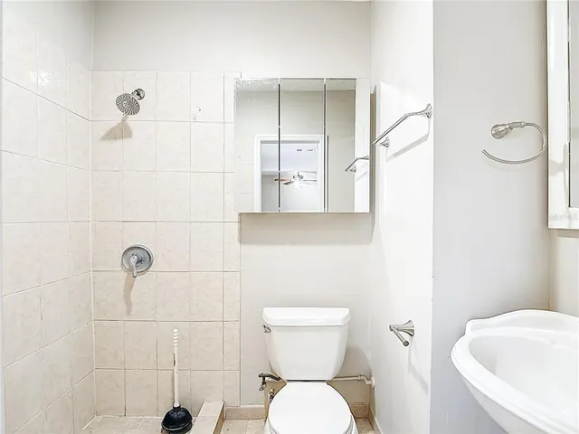 a bathroom with a toilet and a shower