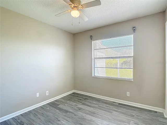 an empty room with a window and wooden floor
