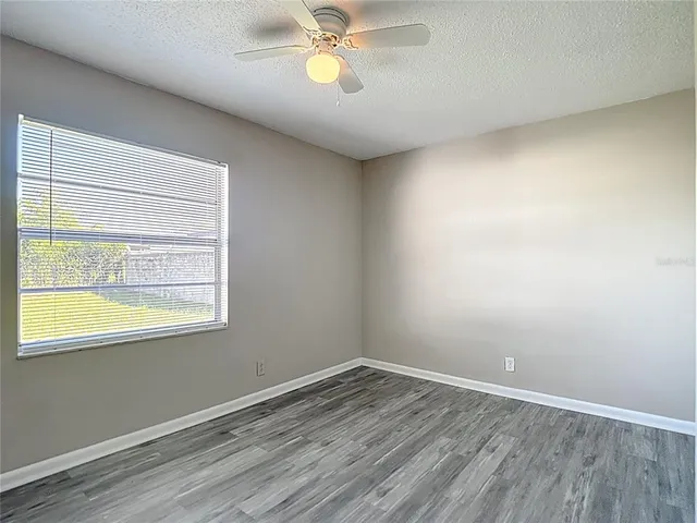 an empty room with a window and wooden floor