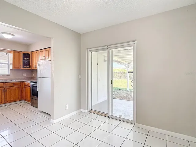 a view of a kitchen with a refrigerator and a stove top oven