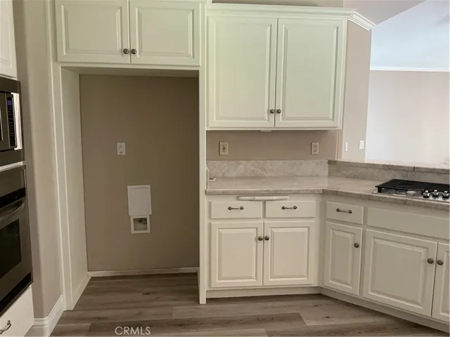 a kitchen with granite countertop white cabinets and white appliances