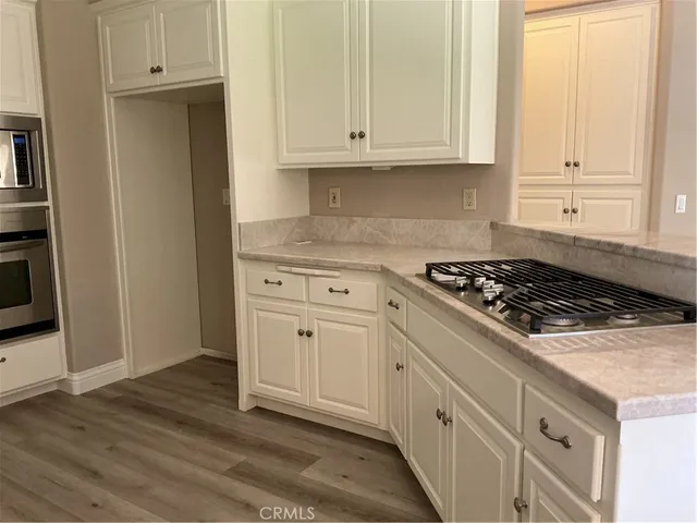 a kitchen with granite countertop white cabinets and stainless steel appliances