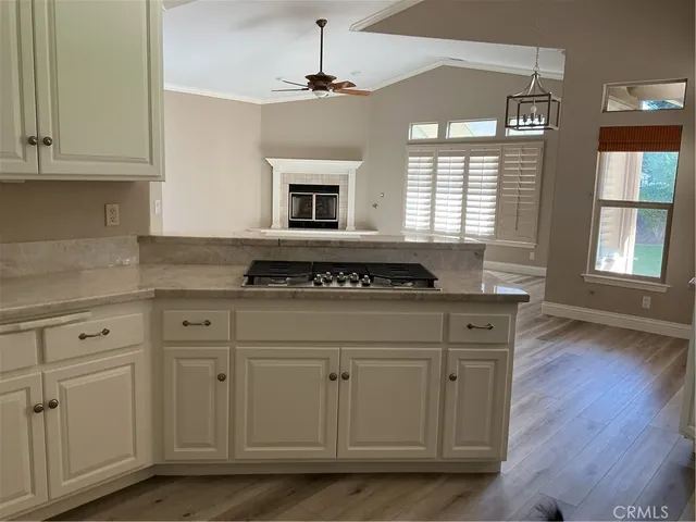 a kitchen with granite countertop white cabinets and a stove