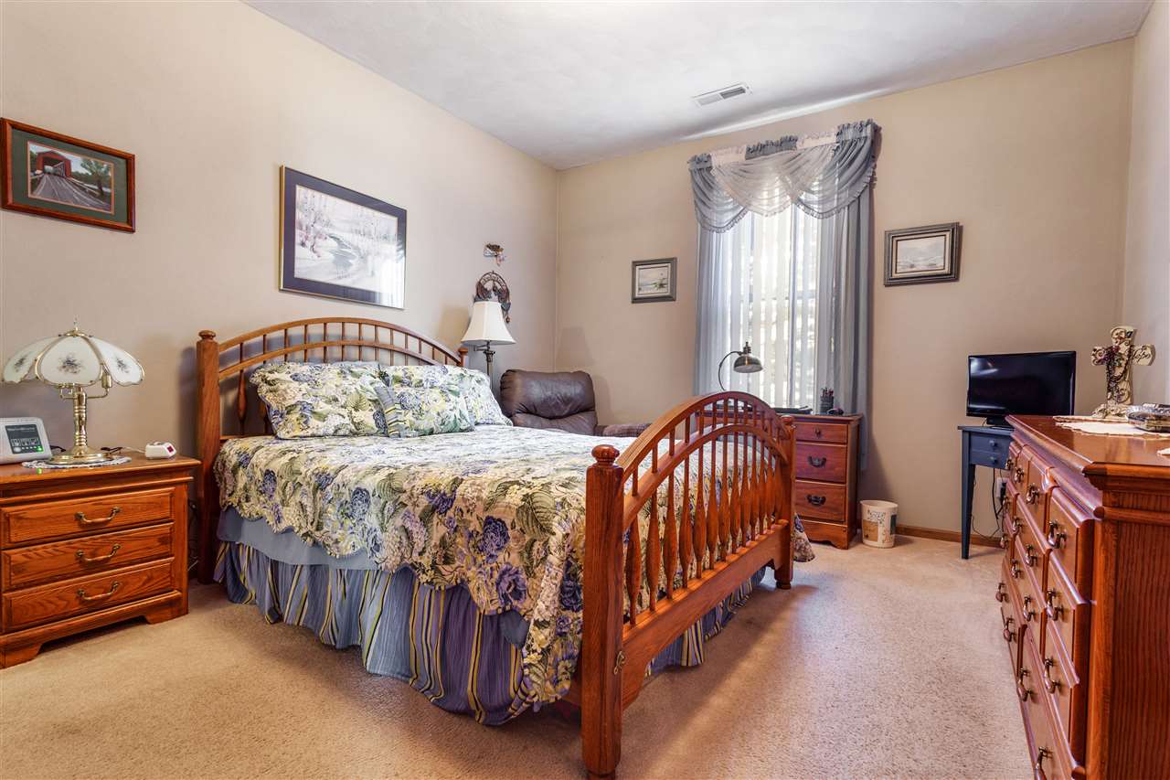 10181 Monarch Road, Unit 3 Roscoe, IL 61073 - Photo 10 of 15 a bedroom with a bed and a chandelier