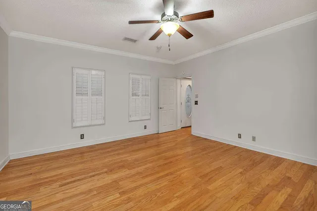 a view of empty room with window and ceiling fan
