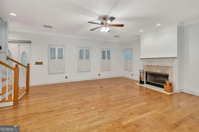 a view of empty room with fireplace and wooden floor