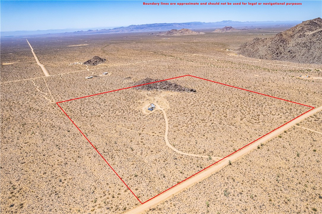 16435 South Wyatt Earp Road Yucca, AZ 86438 - Photo 44 of 57 Expansive desert landscape featuring a dirt access road and distant mountains
