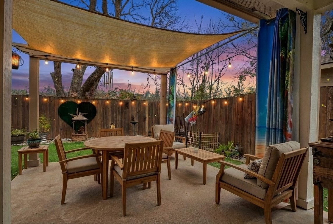 7800 Duber Lane Austin, TX 78747 - Photo 27 of 34 Virtually staged - View of patio at dusk featuring outdoor dining space and artificial turf