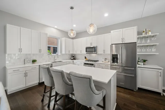 a kitchen with cabinets a sink stainless steel appliances and wooden floor