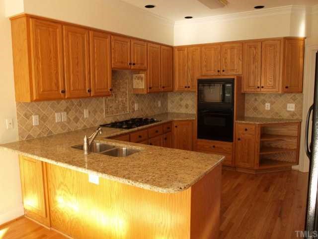 2992 Tillinghast Trail Raleigh, NC 27613 - Photo 5 of 12 a kitchen with granite countertop wooden cabinets and stainless steel appliances