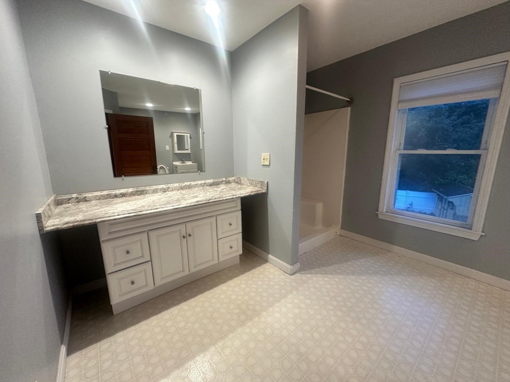 136 Ferry Street, Unit 2 Grafton, MA 01560 - Photo 19 of 29 a spacious bathroom with a granite countertop sink a mirror and a