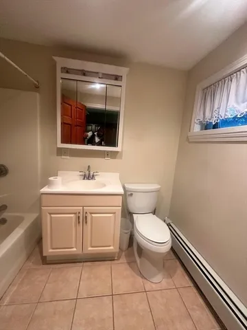 a bathroom with a toilet a sink and mirror