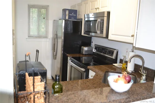 a kitchen with stainless steel appliances granite countertop a sink refrigerator and microwave