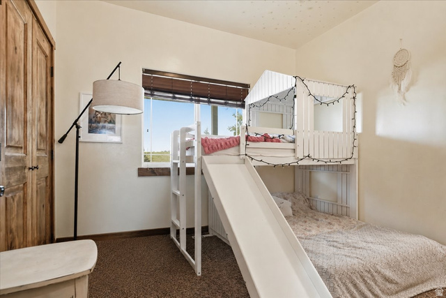 1634 West Arimo Road Arimo, ID 83214 - Photo 17 of 89 Bright room featuring wood-finish bi-fold closet doors, a wide window with wood blinds, and wall-to-wall carpeting