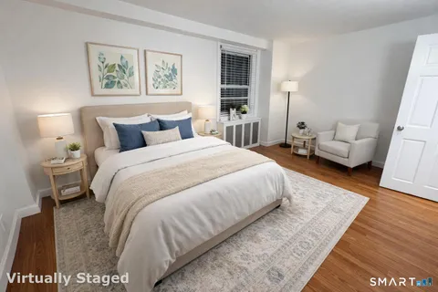 a spacious bedroom with a bed and a rug