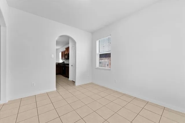 a view of an empty room with window and cabinet