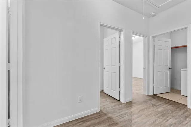 a view of an empty room with wooden floor and closet