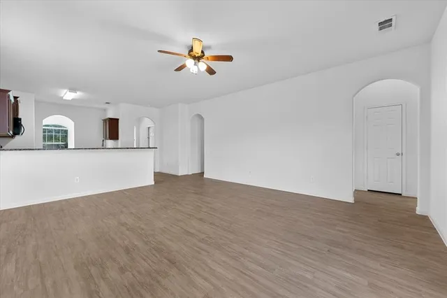 a view of a livingroom with wooden floor and a ceiling fan