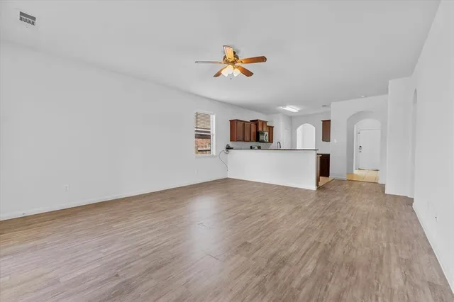 a view of a kitchen with wooden floor and a ceiling fan