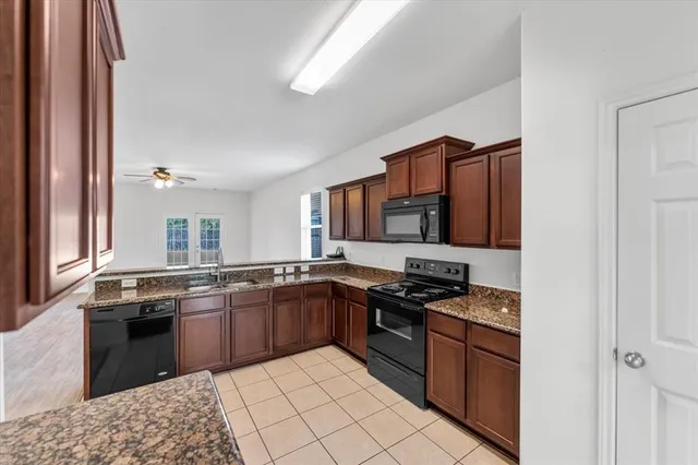 a kitchen with stainless steel appliances granite countertop a stove top oven a sink dishwasher and granite countertops with wooden floor