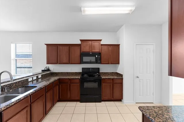 a kitchen with a sink stove top oven and cabinets