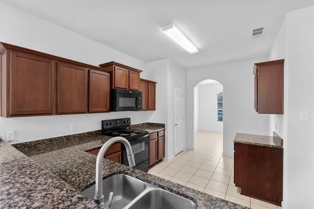a kitchen with stainless steel appliances granite countertop a sink stove and cabinets