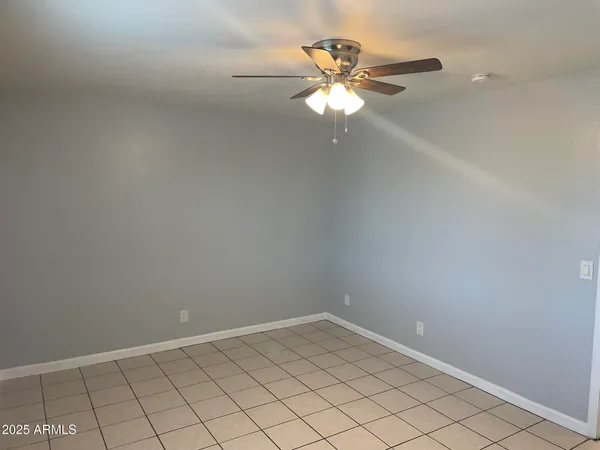 an empty room with chandelier fan