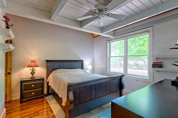 a bedroom with a large bed a flat tv screen and a fireplace