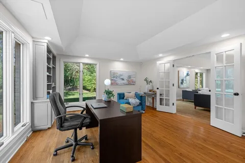 a living room with furniture a wooden floor and a large window