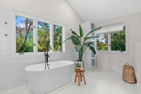 a white bath tub sitting in a bathroom next to a window