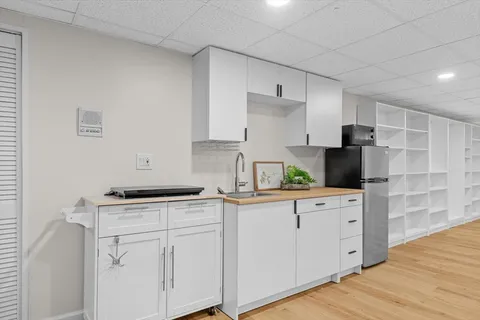 a kitchen with cabinets appliances and wooden floor