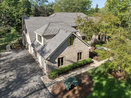 a aerial view of a house with a yard and large trees