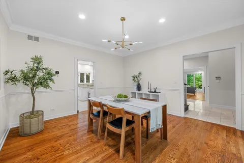 a dining room with furniture potted plants and wooden floor