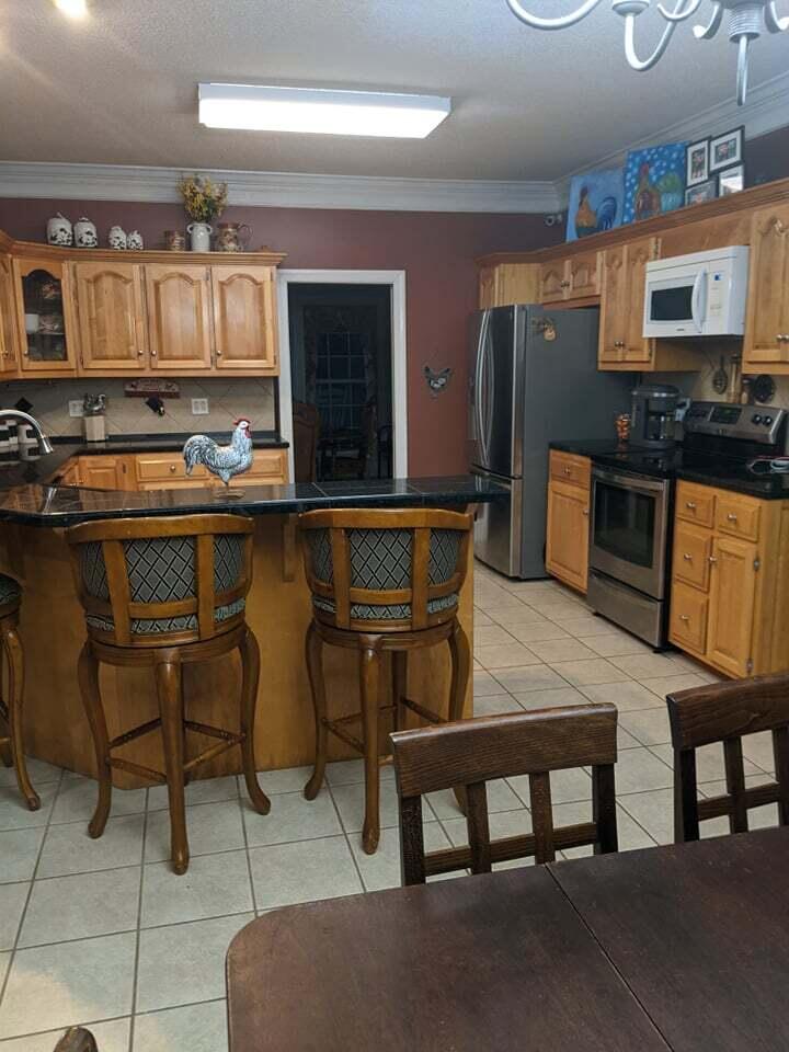 21127 Benvalen Road Andalusia, AL 36420 - Photo 6 of 36 a kitchen with a table chairs microwave and cabinets