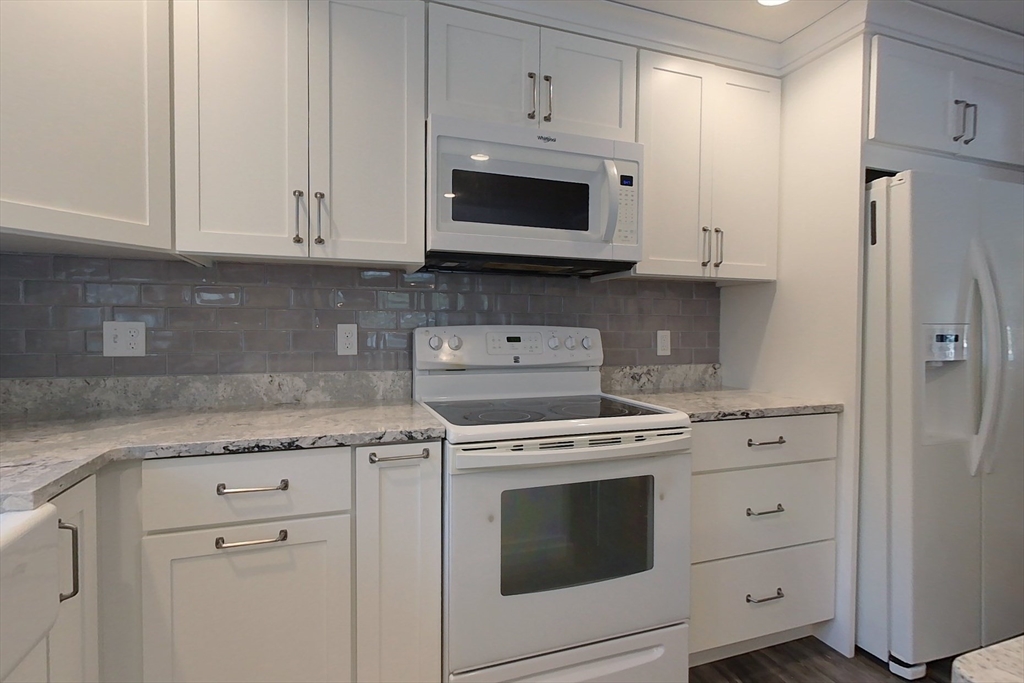 154 Townsend Street Pepperell, MA 01463 - Photo 4 of 42 a kitchen with white cabinets and white appliances