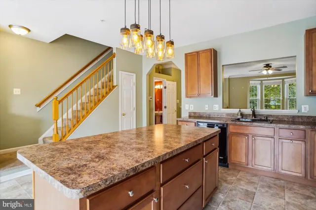 a kitchen with stainless steel appliances a stove a chimney a sink and cabinets