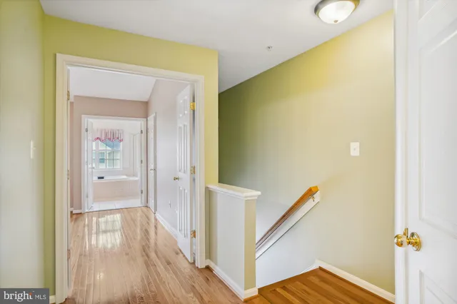 a view of an empty room with wooden floor and closet
