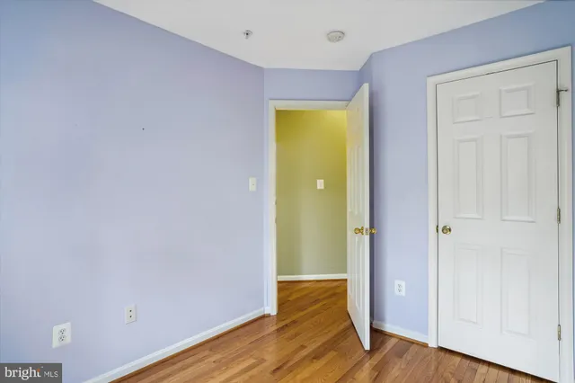 a view of a hallway with wooden floor and closet