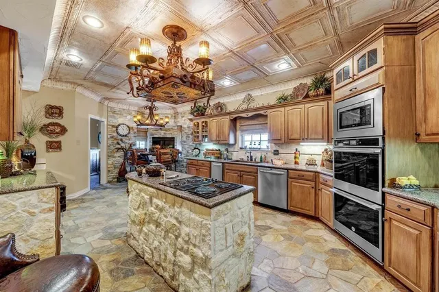 a kitchen with stainless steel appliances granite countertop a sink a stove and cabinets