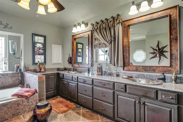 a spacious bathroom with a granite countertop sink a large mirror and a window