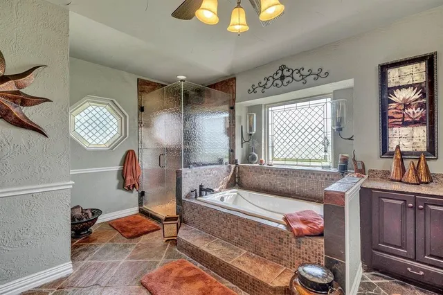 a spacious bedroom with a bed a chandelier and mirror