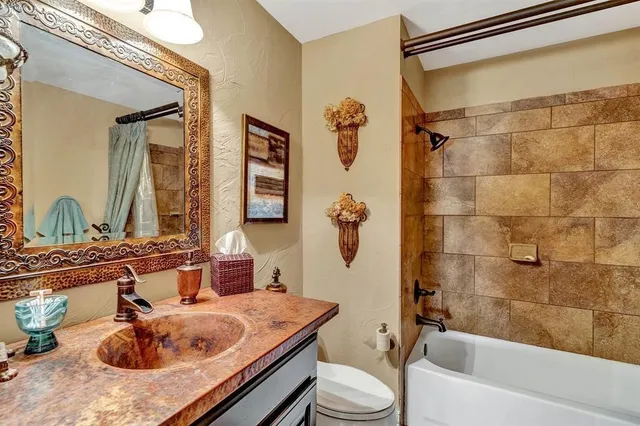a bathroom with a granite countertop sink a mirror a bathtub and shower