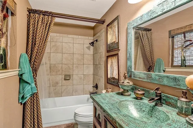 a bathroom with a granite countertop tub sink and mirror