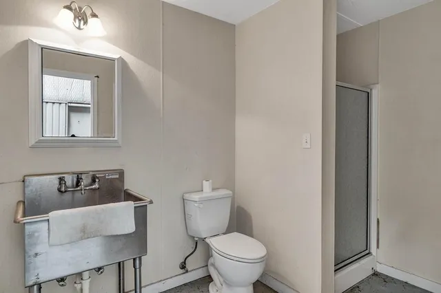 a bathroom with a toilet a sink and mirror