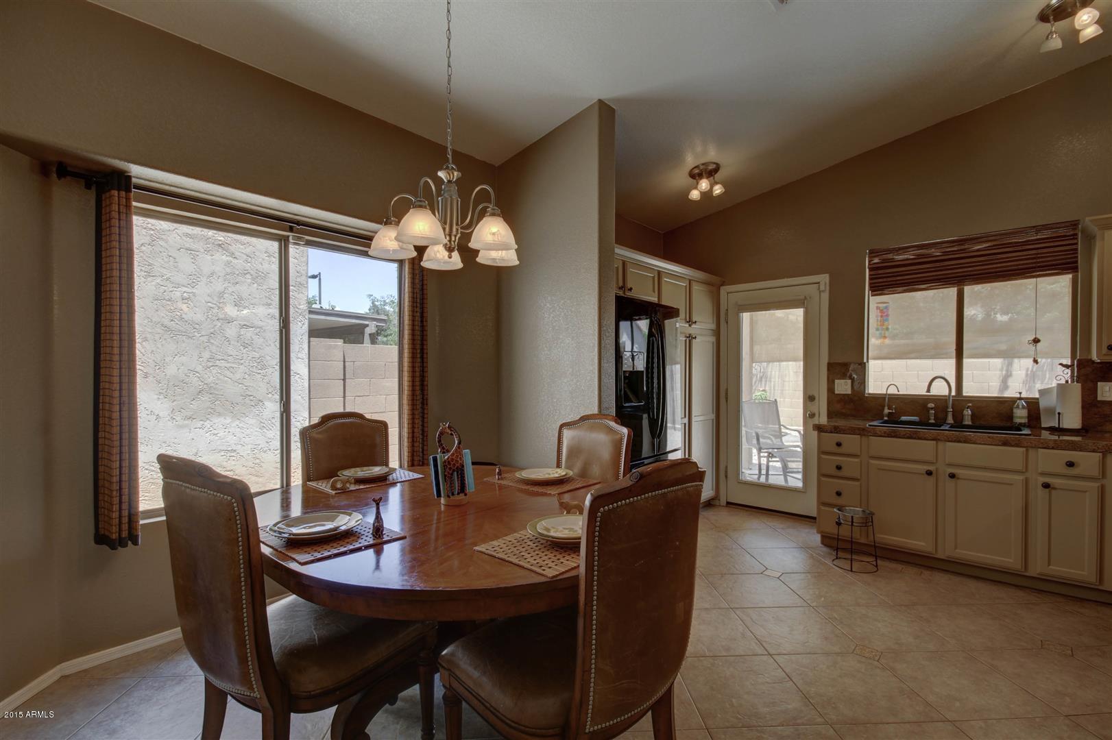 923 South Racine Lane Gilbert, AZ 85296 - Photo 8 of 32 a dining room with furniture a large window and wooden floor