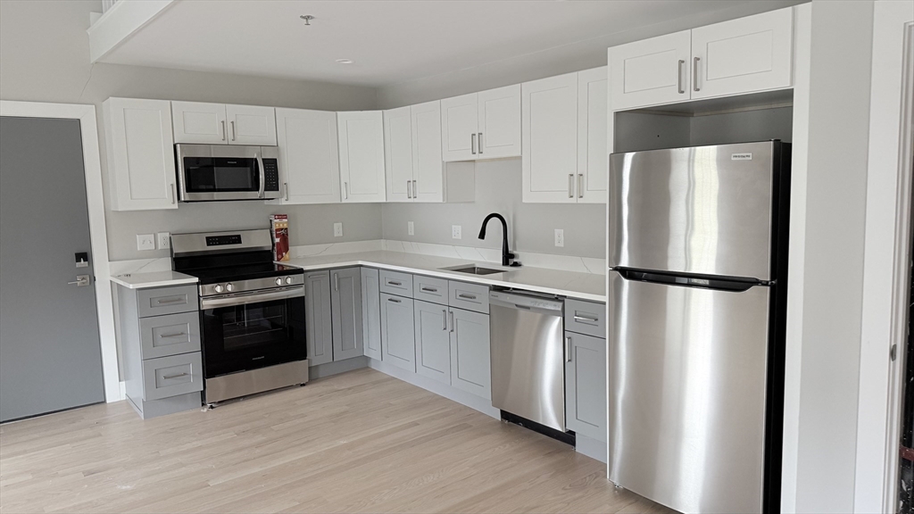 944 East Street, Unit 3 Walpole, MA 02081 - Photo 2 of 23 a kitchen with stainless steel appliances a refrigerator stove and microwave