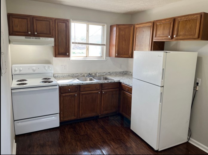 a kitchen with a refrigerator sink stove and cabinets